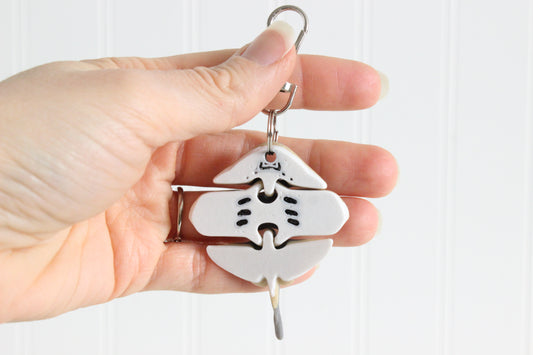 Alternate view of the 3D-printed gray stingray keychain showing its sculpted details and segmented design.