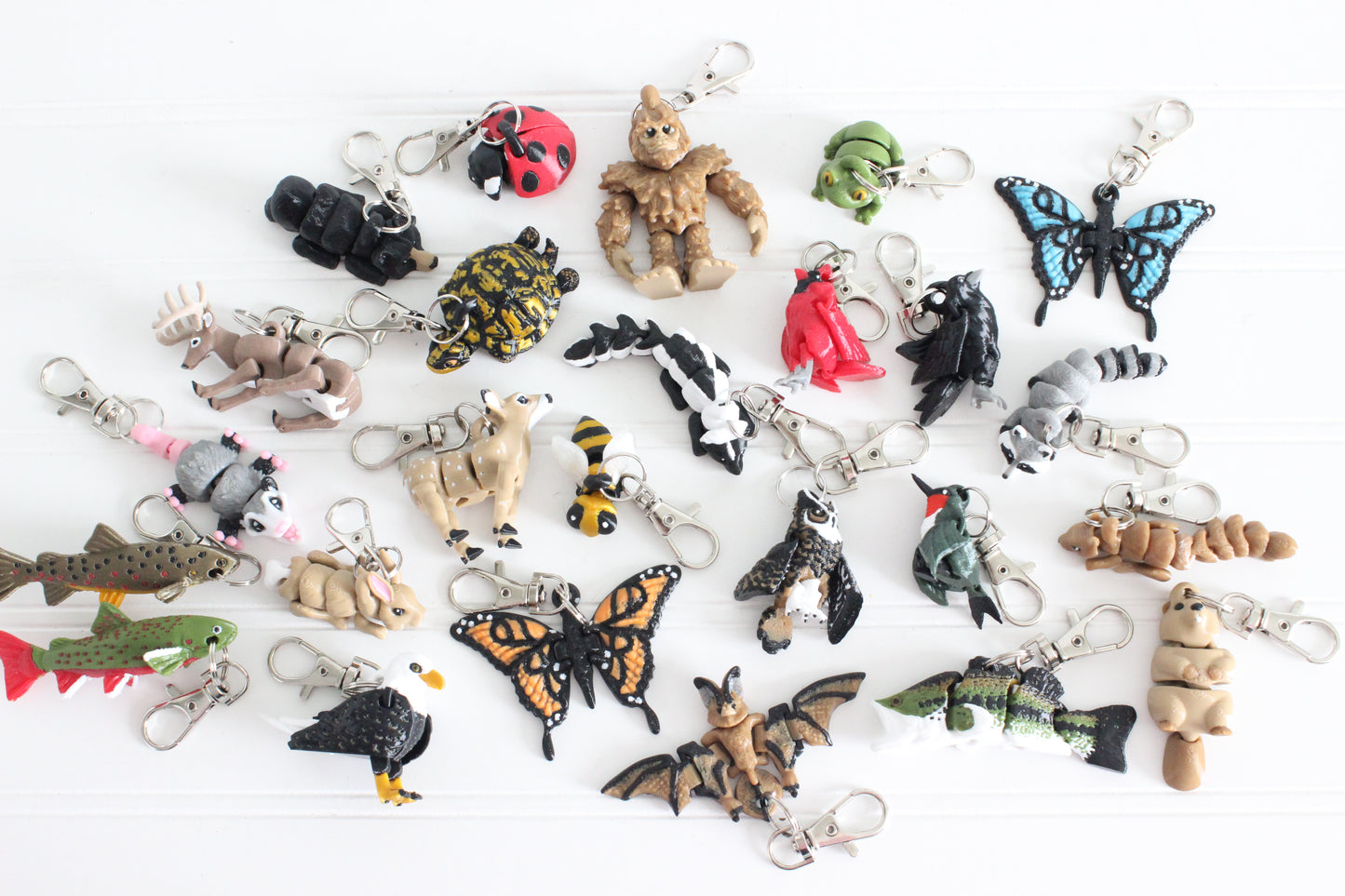 Assorted Mighty Horizons 3D-printed animal keychains, including birds, fish, mammals, reptiles, and insects, on white.