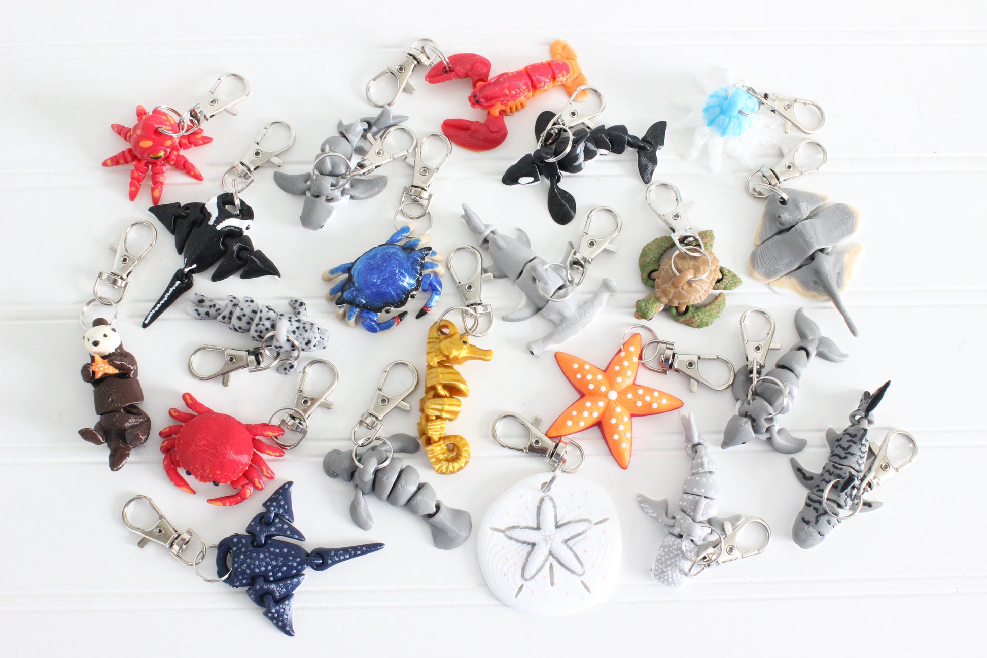 Assorted 3D-printed marine-life keychains, including sharks, whales, dolphins, turtles, rays, octopuses, and seahorses.